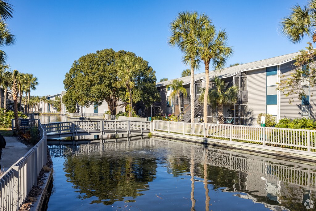 a canal with houses and palm trees next to it