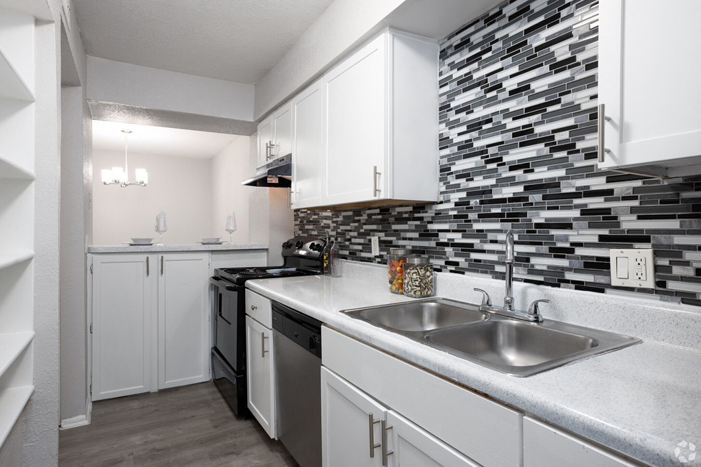 a renovated kitchen with white cabinets and a stainless steel sink