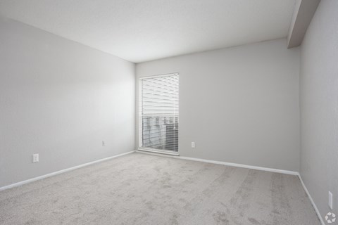 an empty room with a large window and white walls