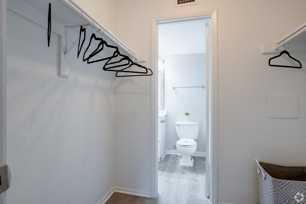 a small bathroom with a toilet and a hallway to a closet