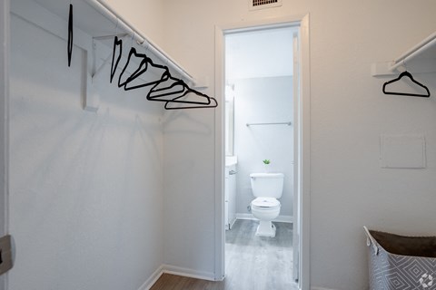 a small bathroom with a toilet and a hallway to a closet