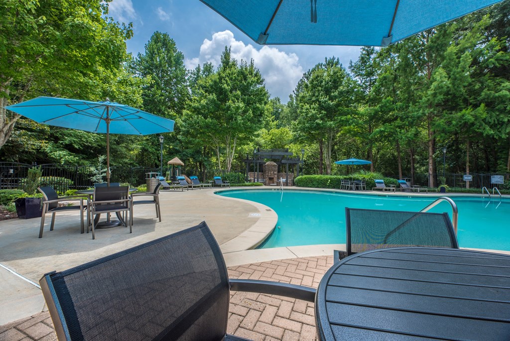 a swimming pool with chairs and umbrellas