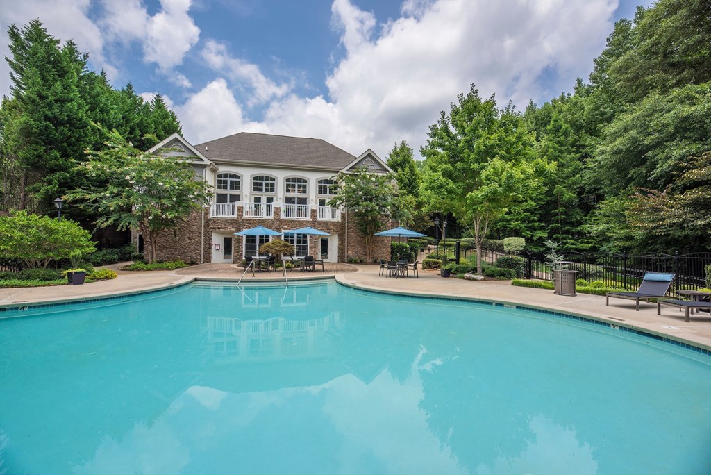 a large swimming pool with a mansion in the background