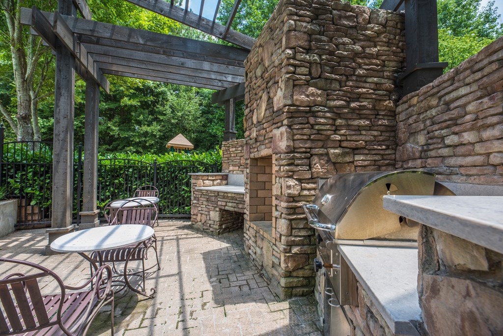 the patio has a pizza oven and tables and chairs