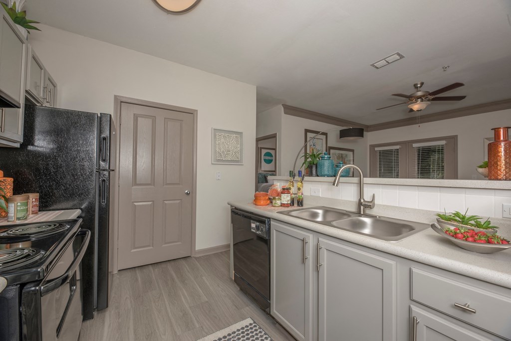 a kitchen with white cabinets and a sink and a refrigerator