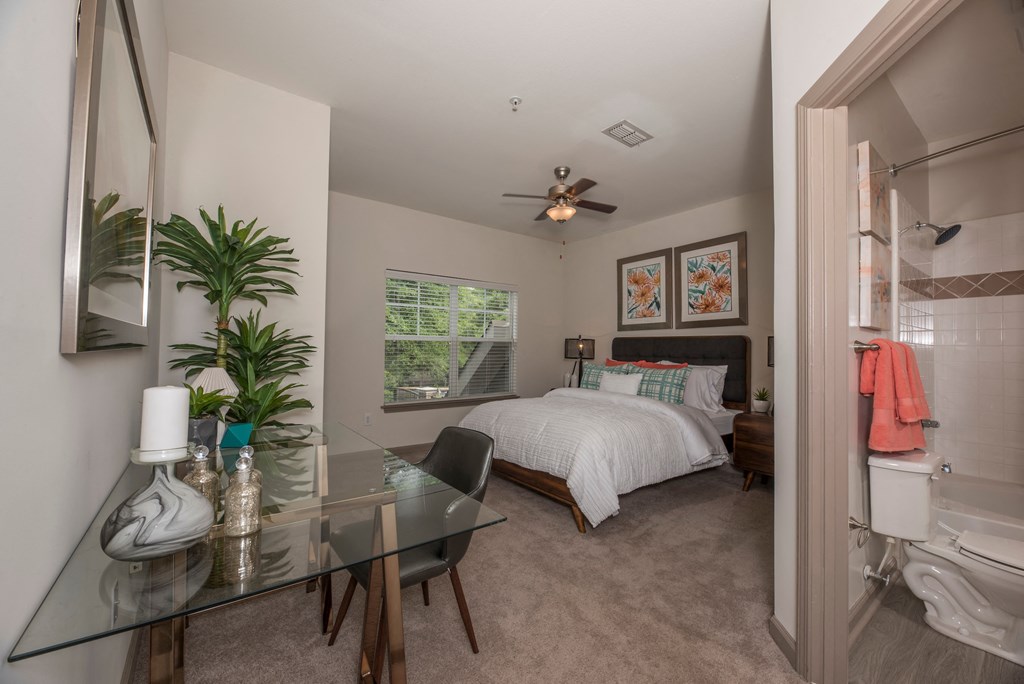 a bedroom with a bed and a glass desk