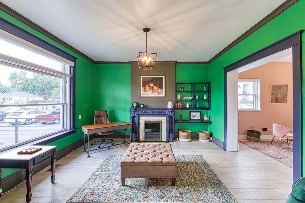 a living room with green walls and a fireplace