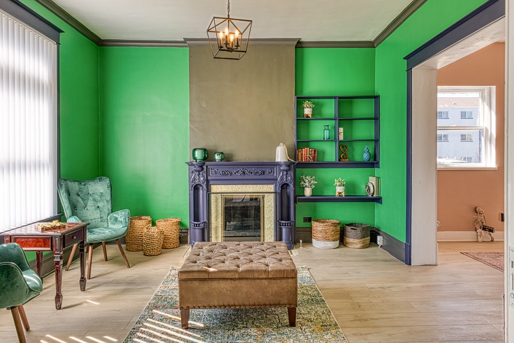 a living room with green walls and a blue fireplace