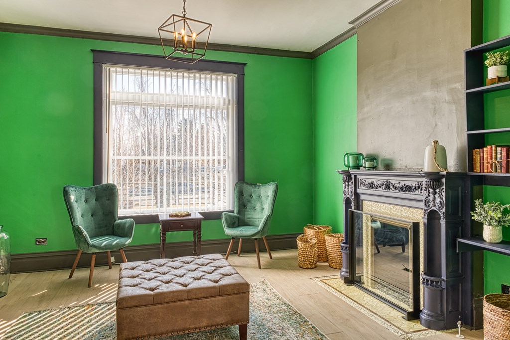 a living room with green walls and a fireplace