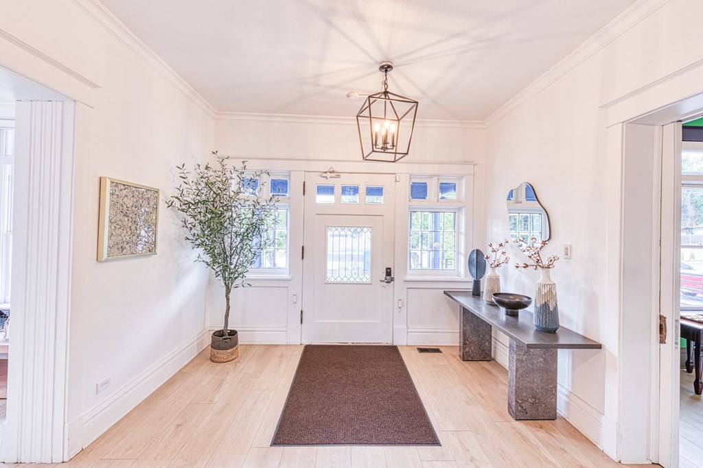 a hallway with white walls and wood floors and a large white door