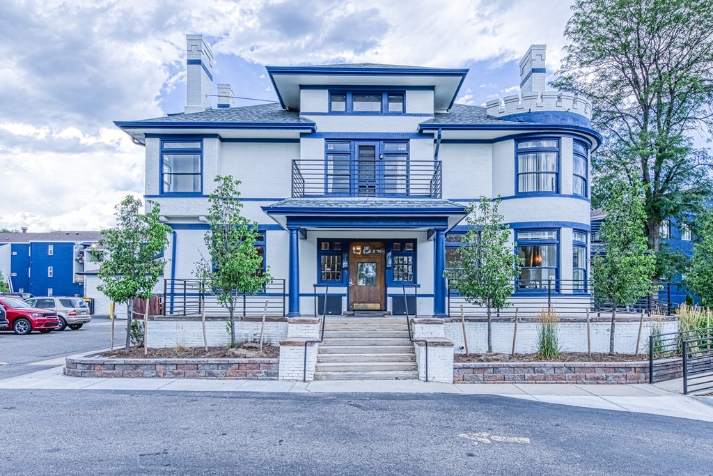 the front of a blue and white house with stairs