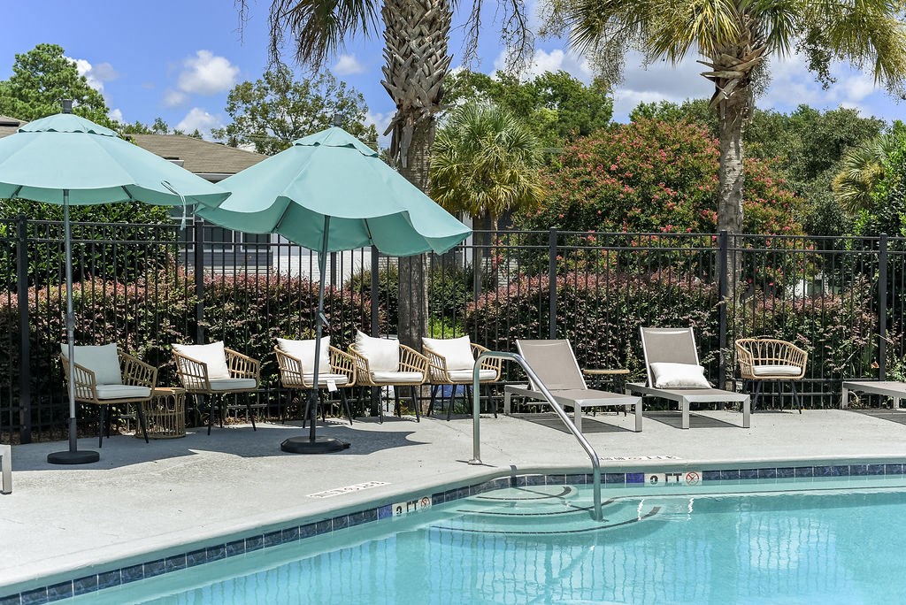 a swimming pool with chaise lounge chairs and umbrellas