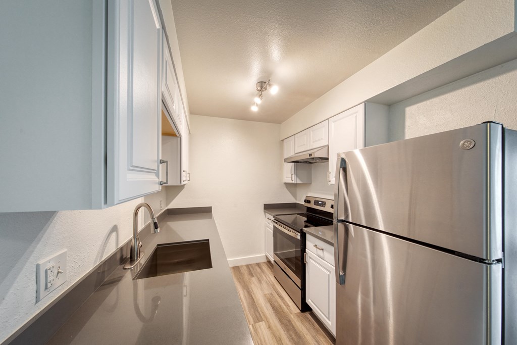 a kitchen with stainless steel appliances and white cabinets