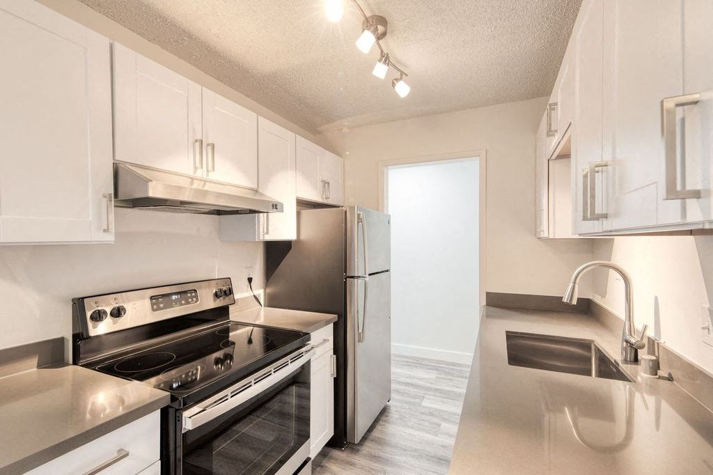a kitchen with white cabinets and stainless steel appliances