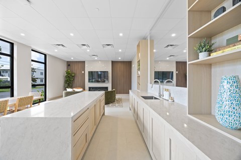 A modern kitchen with a long counter and a sink.