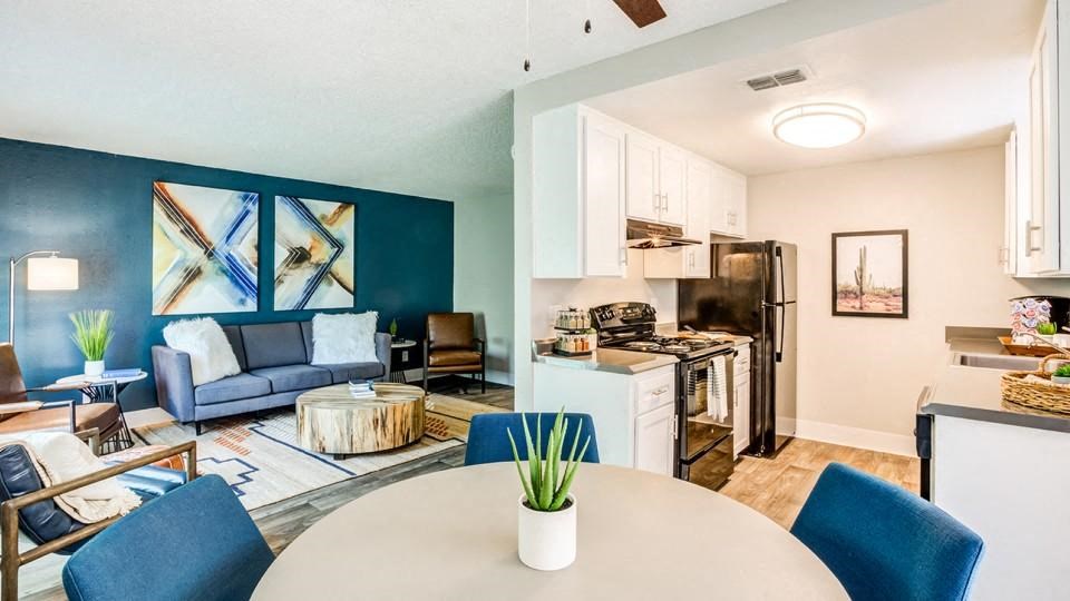 a kitchen and living room with a table and chairs