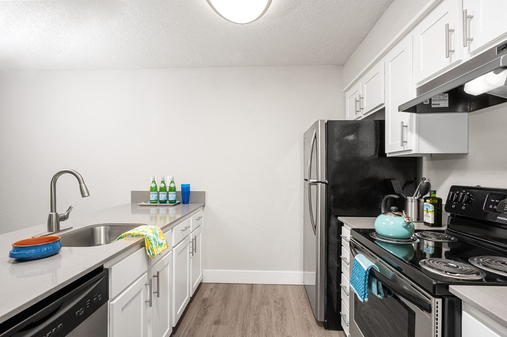a kitchen with white cabinets and black appliances