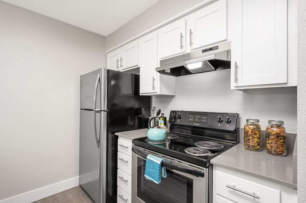 a kitchen with white cabinets and stainless steel appliances
