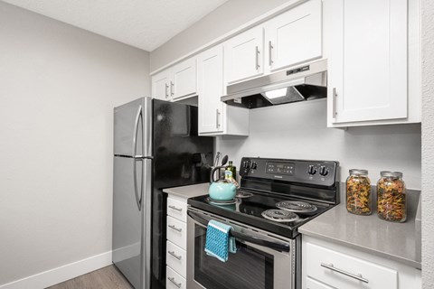 a kitchen with white cabinets and stainless steel appliances
