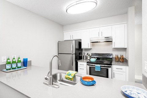 a kitchen with white cabinetry and stainless steel appliances