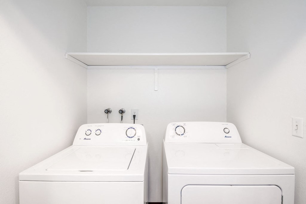 a laundry room with two washers and a dryer