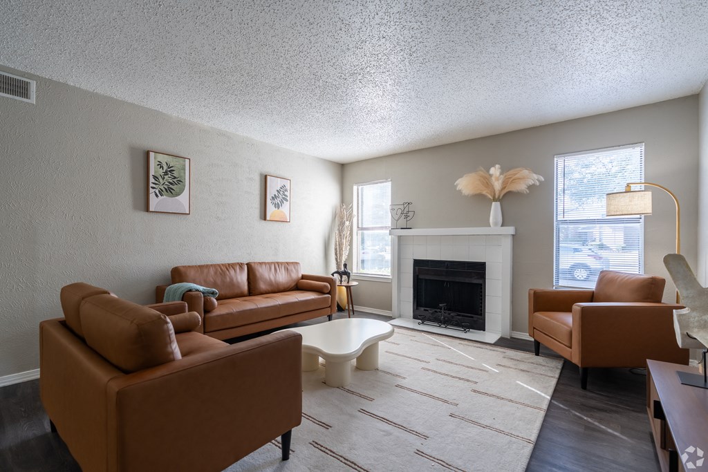 A living room with a fireplace and a brown couch.