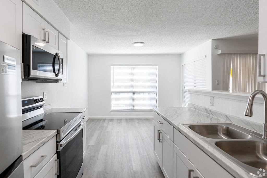 A kitchen with a stove, oven, and sink.