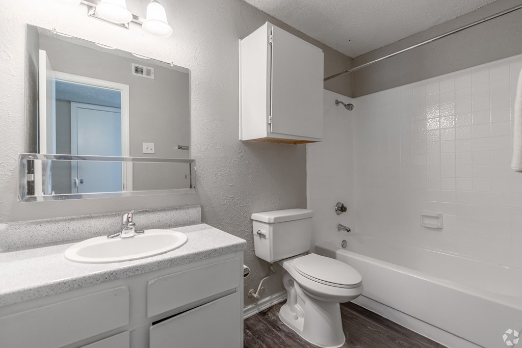 A white bathroom with a toilet, sink, and bathtub.