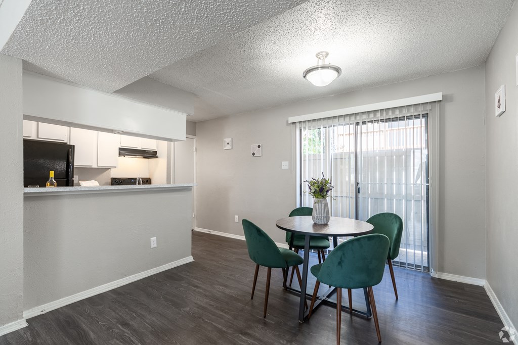 A dining room with a table and chairs.