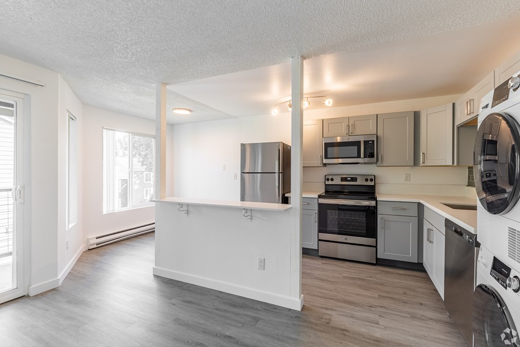 A kitchen with a refrigerator, oven, and microwave.