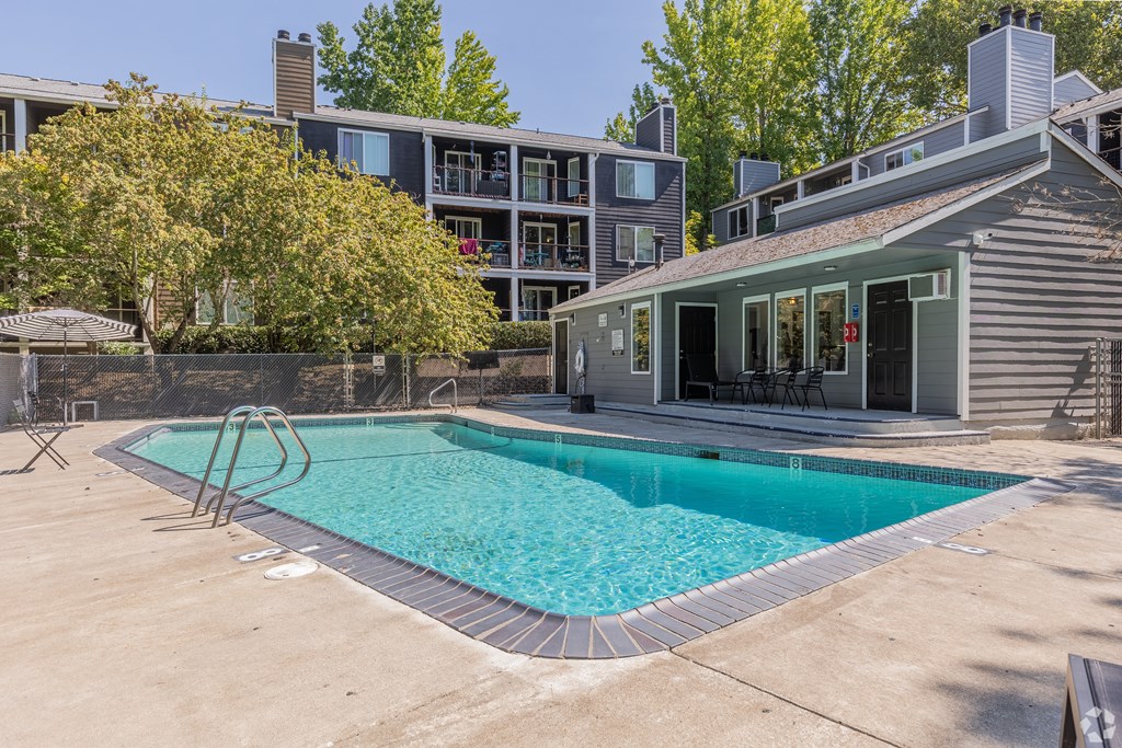 A swimming pool in a backyard with a house in the background.