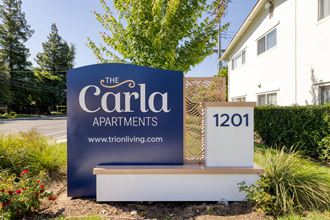 a sign in front of a house that says the carla apartments