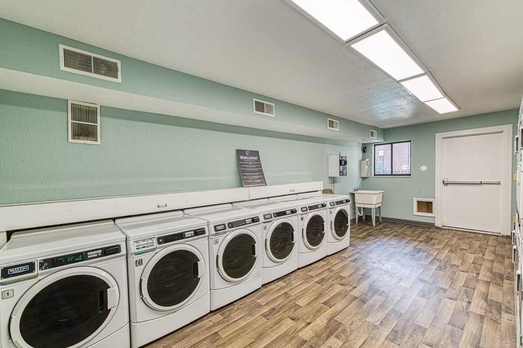 a washer and dryer in a room with a wood floor