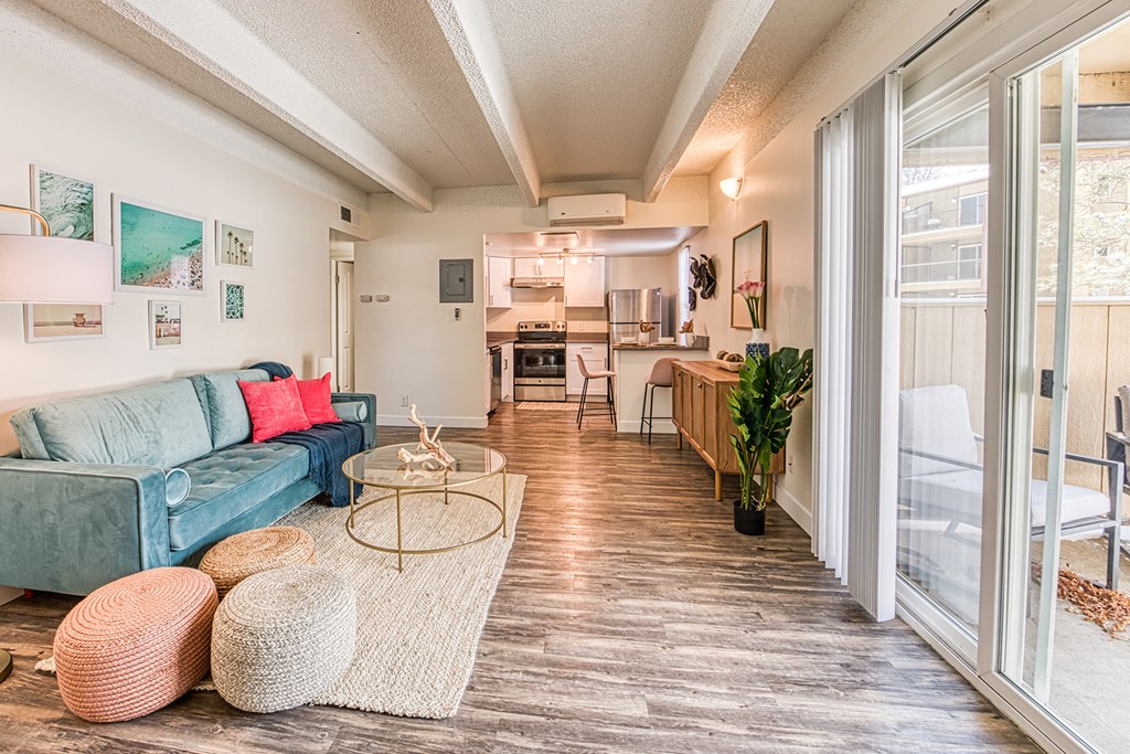 a living room with a blue couch and a glass coffee table
