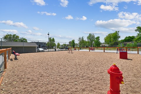 A red fire hydrant sits in the middle of a playground.