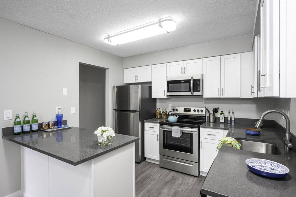 a kitchen with white cabinets and stainless steel appliances