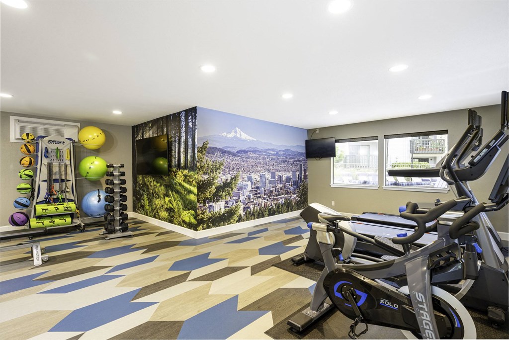a home gym with a large mural on the wall