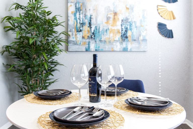 a table set with plates and glasses and a bottle of wine