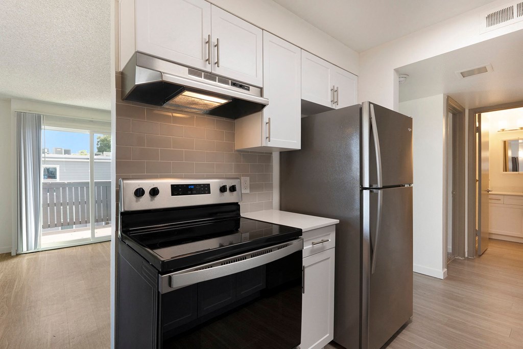 A modern kitchen with a black stove top oven and a black refrigerator.