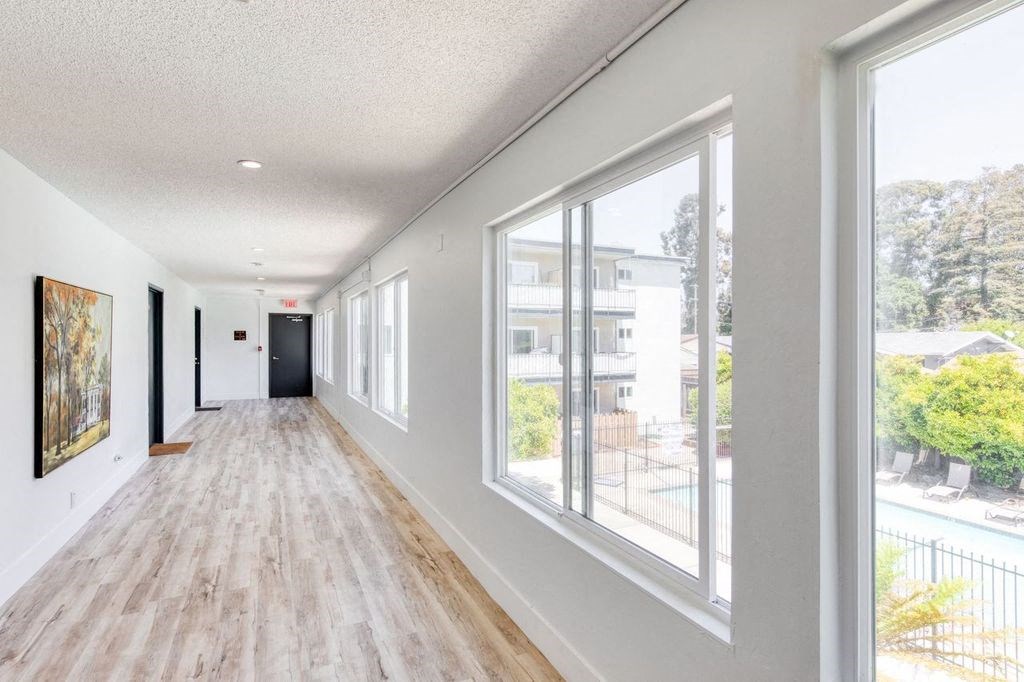a long hallway with large windows and a wooden floor