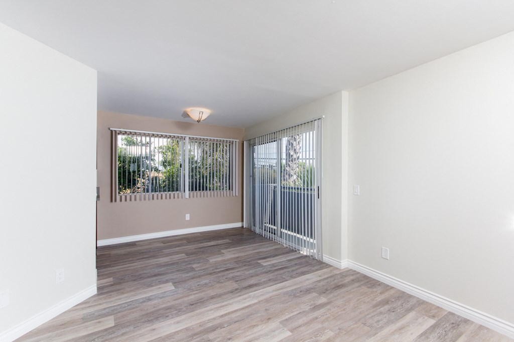 a bedroom with hardwood floors and white walls