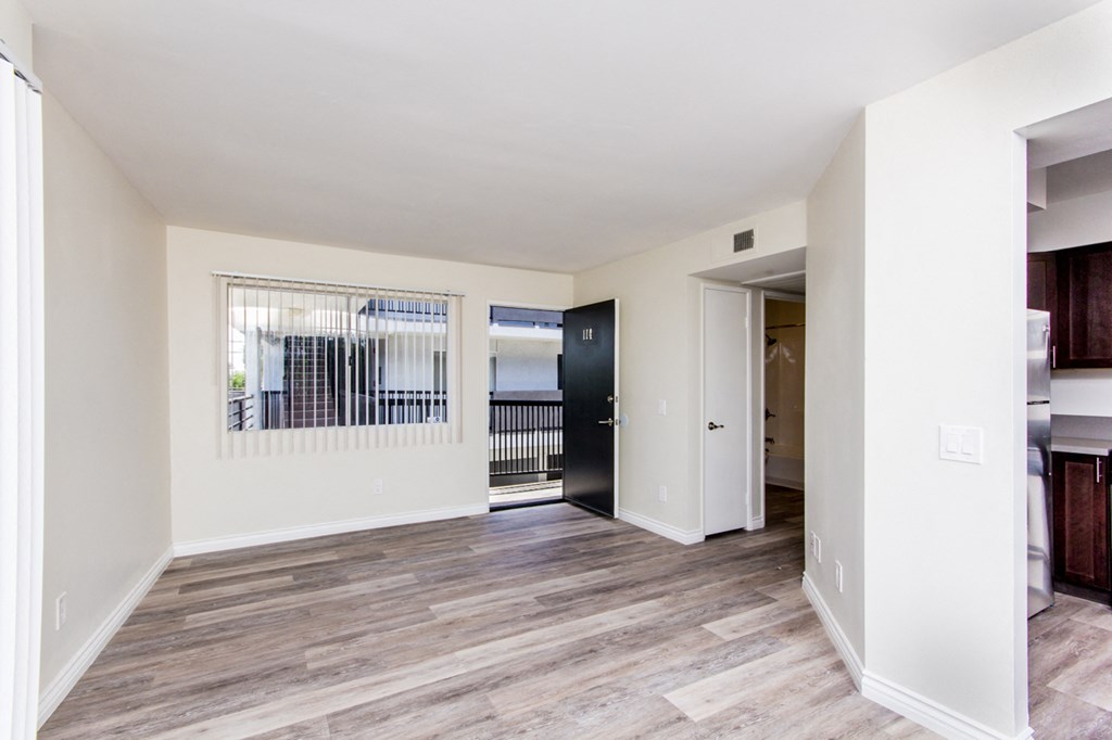 a bedroom with hardwood flooring and white walls