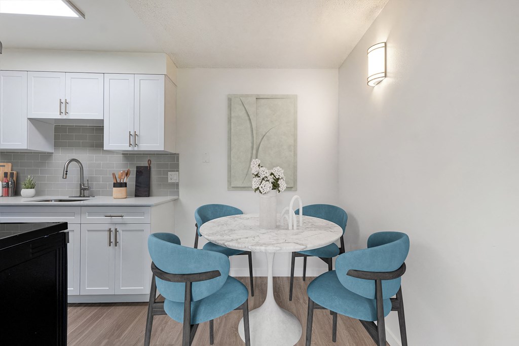 A kitchen with a table and chairs.