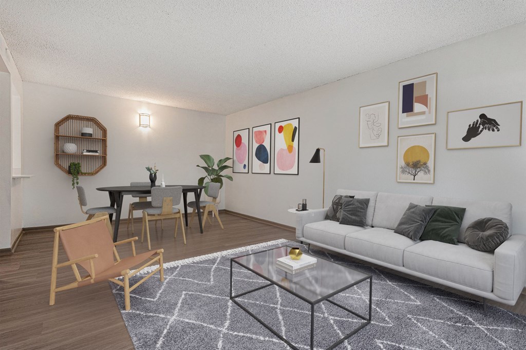 A living room with a white couch, a coffee table, and a dining table with chairs.