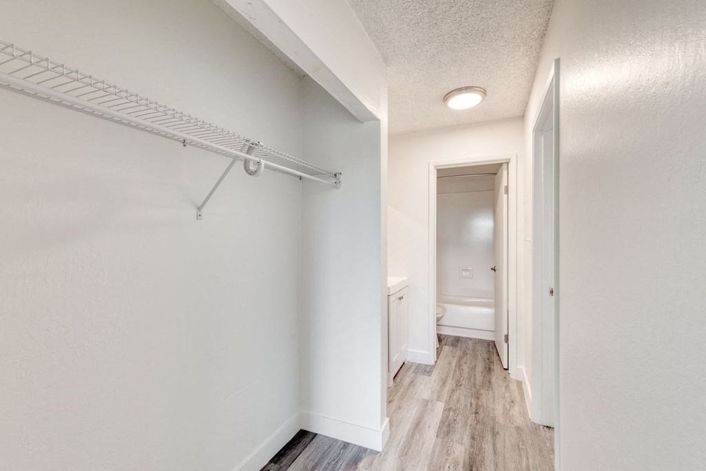 a bedroom with a medium sized closet and a bathroom in the background