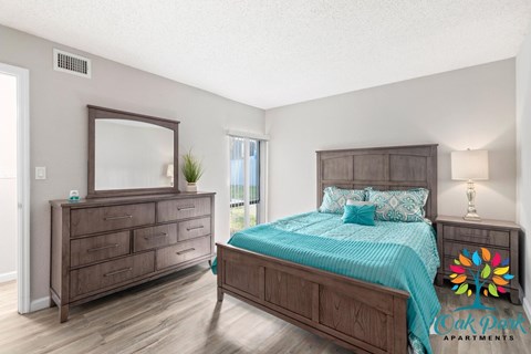 A bedroom with a bed, dresser, and mirror.