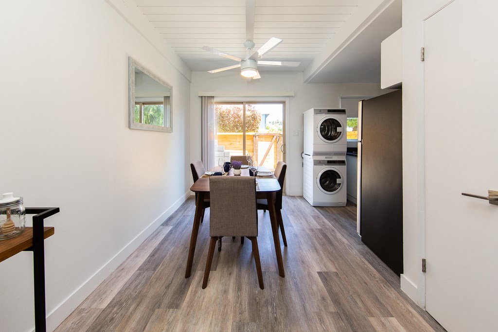 a dining area with a table and chairs and a washer and dryer