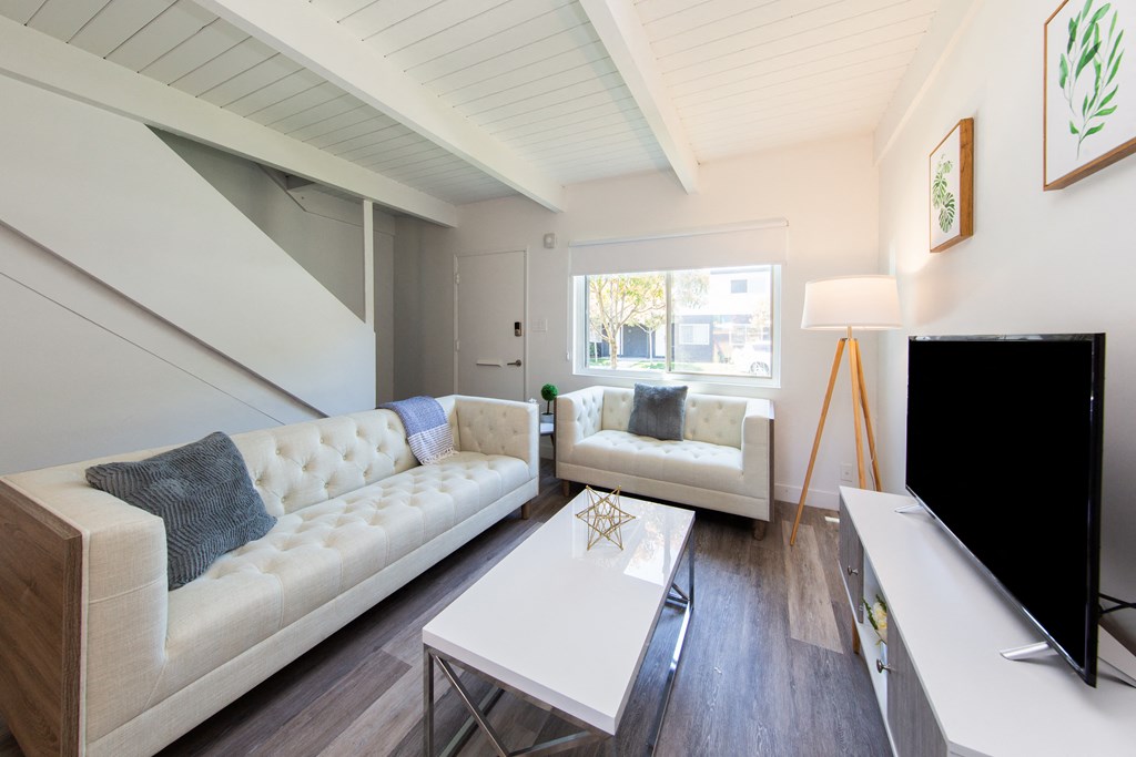 a living room with white couches and a white coffee table