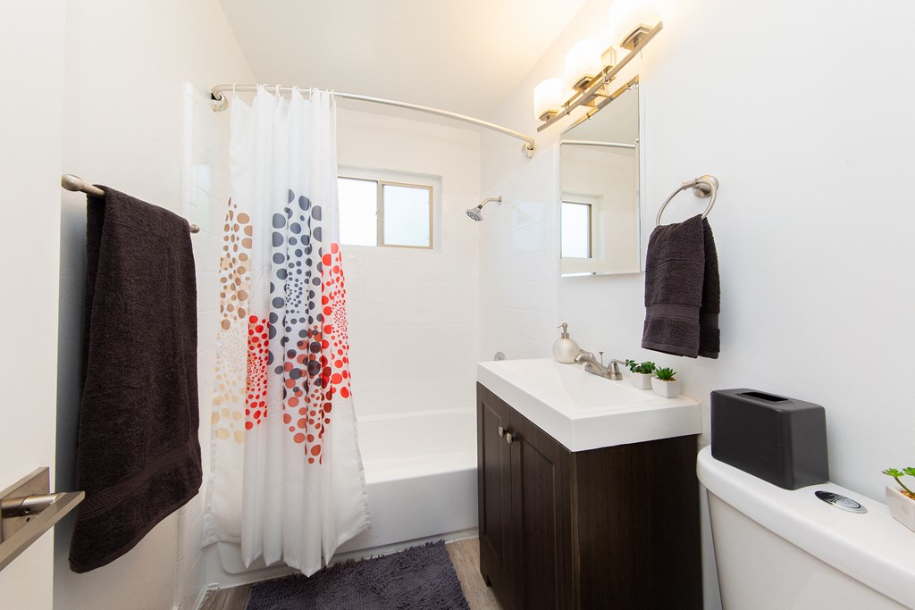 a bathroom with a white sink and a shower with a shower curtain