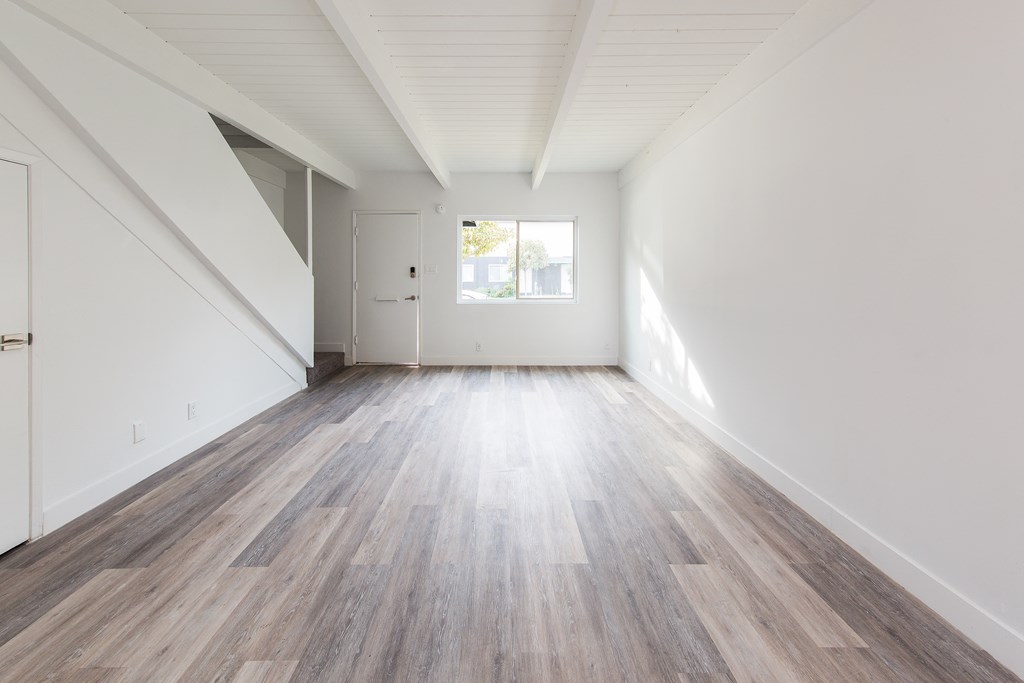 a bedroom with hardwood floors and white walls